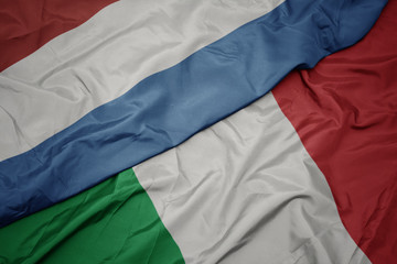 Fototapeta premium waving colorful flag of italy and national flag of luxembourg.