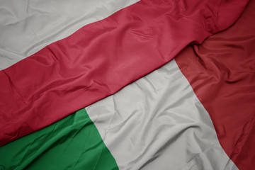 Fototapeta premium waving colorful flag of italy and national flag of poland.