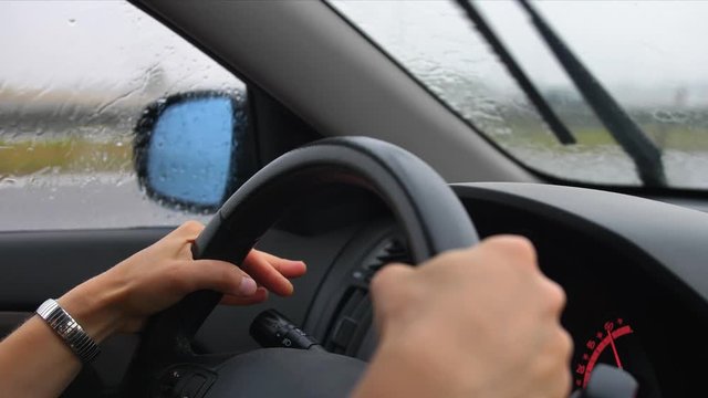 Car Dashboard and Female Hands Holding Steering Wheel When Driving in Heavy Rain