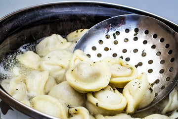meat dumplings are boiled in a pot of boiling water