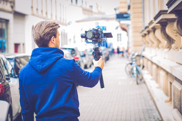 Handsome Influencer Vlogger Make Video with Mirrorless Camera and Gimbal in The City