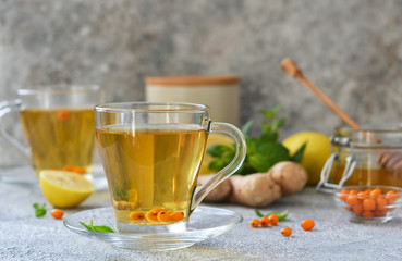 Tea with mint and sea buckthorn on a concrete background with space for text. Advertising.