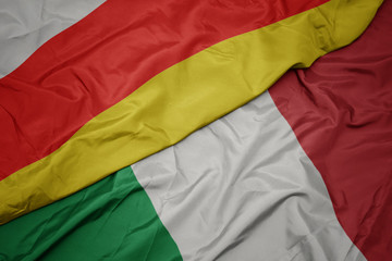 waving colorful flag of italy and national flag of south ossetia.