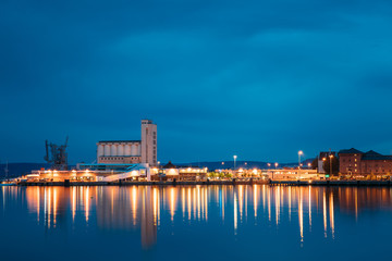 Fototapeta premium Oslo, Norway. Night View Embankment And Sea Port Terminal In City Center In Oslo, Norway. Summer Evening. Lights Reflected In Sea Water