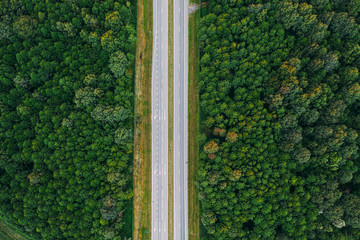 Aerial View Of Highway Road Through Green Forest Landscape In Summer. Top View Flat View Of Highway Motorway Freeway From High Attitude. Trip And Travel Concept