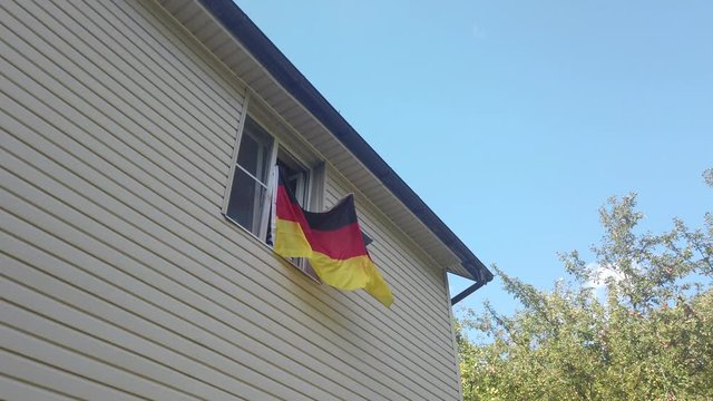 Young people waving a flag in a window at home