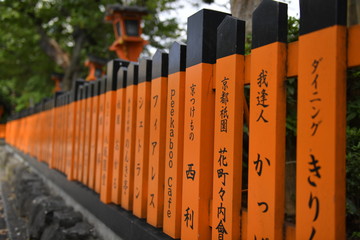 Wooden fence in japan is painted orange with black japanese symbols