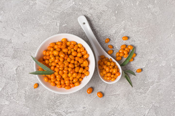 Fresh ripe sea buckthorn berries in white bowl