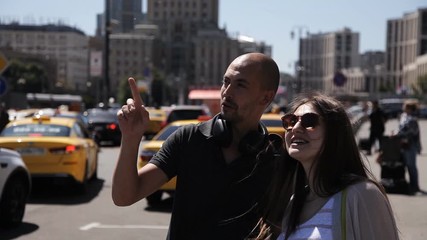 A man will help the newly arrived girl to navigate in the metropolis. A man points the way to a tourist lost in a big city