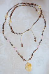 Fototapeta na wymiar Citrine mineral stone pendant natural beads necklace on neutral background