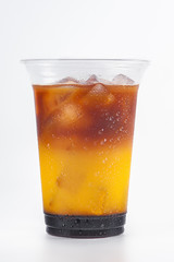 Cold drink with coffee, orange juice and ice cubes on a white background