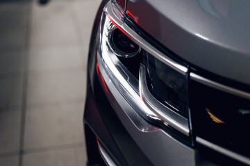 Obraz na płótnie Canvas Closeup headlights of a modern car. Detail on the front light of a car. Modern and expensive car concept