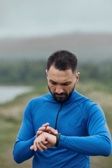 Handsome bearded man checking up his smart watch