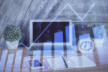 Double exposure of chart and financial info and work space with computer background. Concept of international online trading.