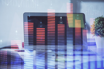 Stock market graph on background with desk and personal computer. Multi exposure. Concept of financial analysis.