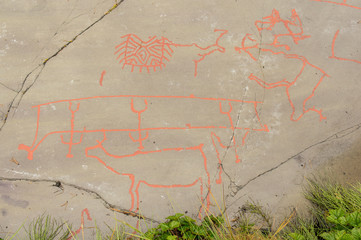 Rock art in Alta Fjord, Norway. Ancient symbols, real drawing,  texture in stone. Red ocher paint. Human preys on animals deer.  Group of petroglyphs, dating from c. 4200 to 500 B.C.