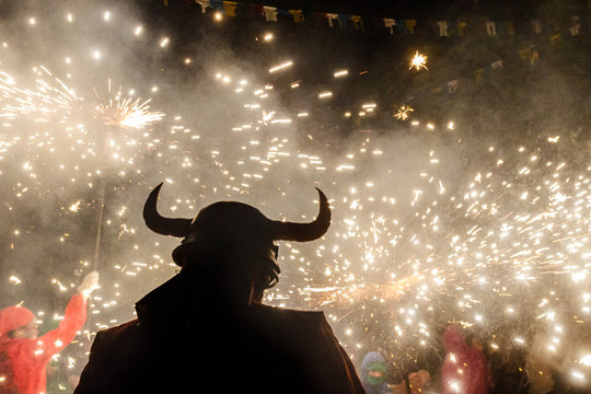 Fiesta tipica catalana de los correfocs, con siuelta de demonio con cuernos y fuegos de artificio 