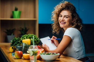 Nutritionist working in office. Doctor writing diet plan on table and using vegetables. Sport trainer. Lifestyle. - obrazy, fototapety, plakaty