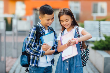 Two school child playing with smart watch with happy smile. Learning new technology.