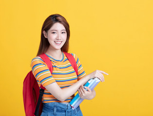 Portrait of beautiful asian young student holding books