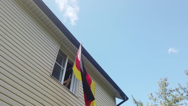 Young people waving a flag in a window at home
