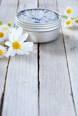Obraz na płótnie Canvas blue bath salt in tin pot on natural old wood table texture