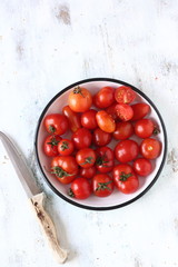 Raw cherry tomato on a white wooden background