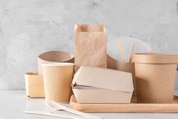 set of eco friendly disposable dishes made of bamboo wood and paper on white marble background