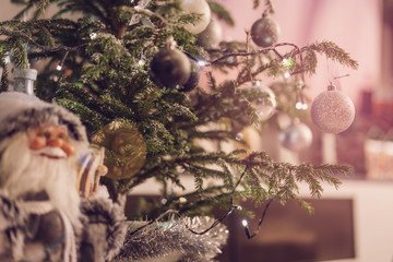 beautiful glass toys balls hang on Christmas tree, figure of Santa Claus in foreground