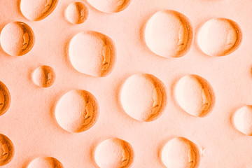 Water drops on orange abstract background, top view
