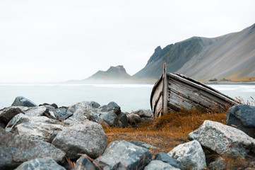 Old wooden boat on the shore of Atlantic ocean in Iceland. Selective focus