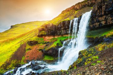 Beautiful waterfall in eastern Iceland at sunset. Summer landscape