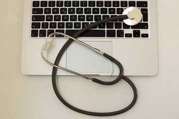 medical stethoscope on a black laptop keyboard