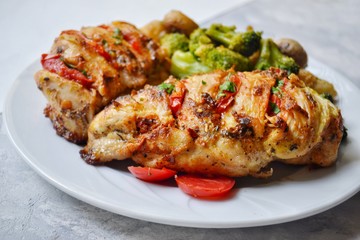Fried chicken fillet. Broccoli and cauliflower. Baked chicken breast. Chicken and tomato. Food in a white plate on a light table background.