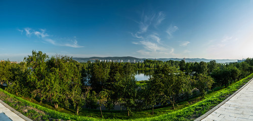 View form central park embankment on Enisei river and green island in Krasnoyarsk, Russia