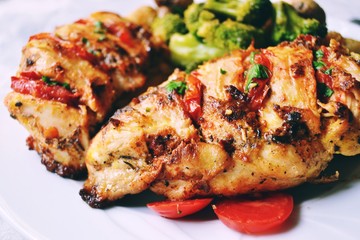 Fried chicken fillet. Broccoli and cauliflower. Baked chicken breast. Chicken and tomato. Food in a white plate on a light table background.