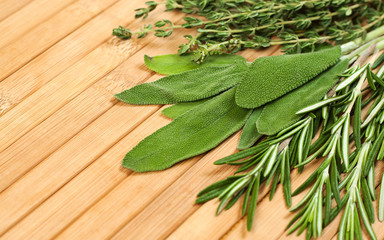 Collection of fresh herbs for cooking isolated on wooden background. Bunch of herbs