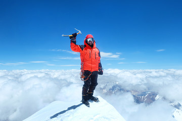 Happy man climber in bright red down jacket reaches the summit of mount Everest, Nepal. - obrazy, fototapety, plakaty