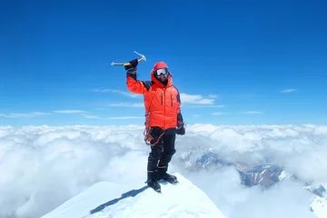 Photo sur Plexiglas Everest Heureux homme grimpeur en doudoune rouge vif atteint le sommet du mont Everest, au Népal.