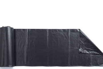 Unwound black plastic garbage bags isolated on white background on white background. Close up garbage bags with copy space