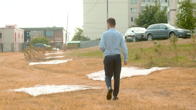 Incorrectly planted lawn. The grass dried up. Inspector looks at the grass. Check of planting in the city park