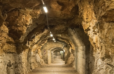 Underground stone tunnel with the light bulbs all over the way, stone underground passage - Image