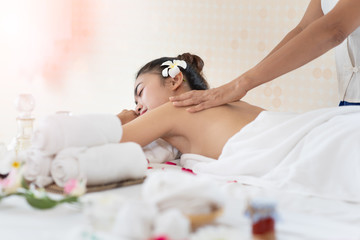 Young Asian woman getting massage in the spa salon, enjoying and relaxing