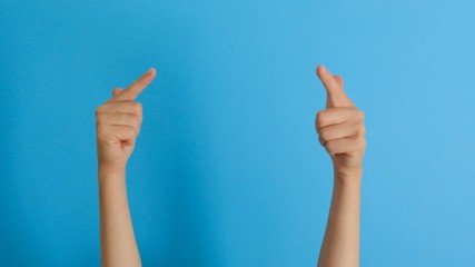 Woman hands indicate forefinger at blank copy space up over blue background. Body language concept.