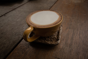 The coffee latte in a brown cup on the table