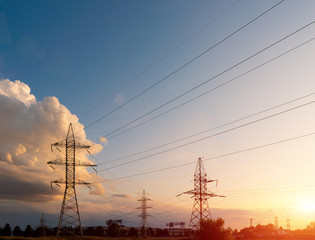 Power lines during a beautiful sunset. Transportation of electricity through the beautiful landscapes of the world.