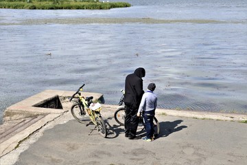 body of water, people, bicycles