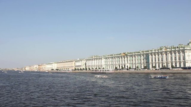 tourist pleasure boats in the Neva river on the background of the Winter Palace and the embankment