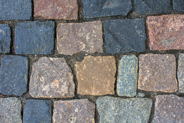 old stone wall made of bricks of various shapes, sizes and colors. rough surface texture