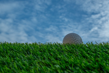 Golf ball on grass and blue sky background